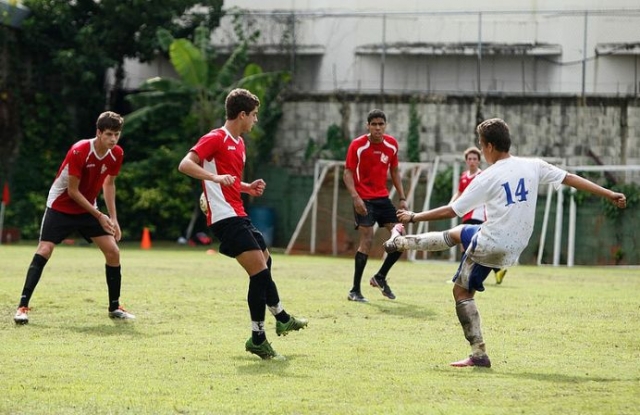  jovens jogando futebol em um campo de futebol 